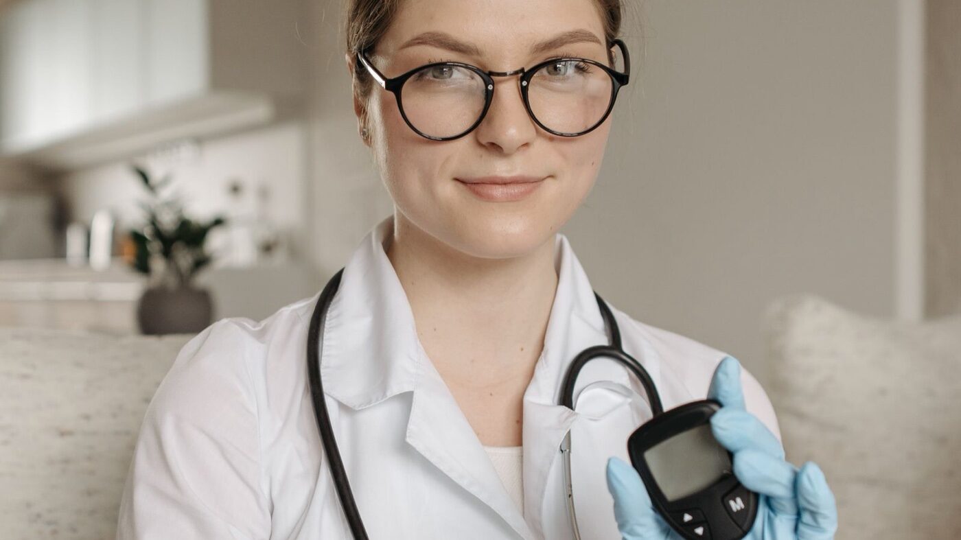 Profesional médica mostrando un medidor de glucosa